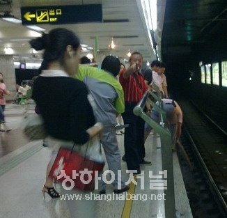 ▲지하철공사 직원이 선로에 떨어진 사고피해자의 신발을 줍고 있다.