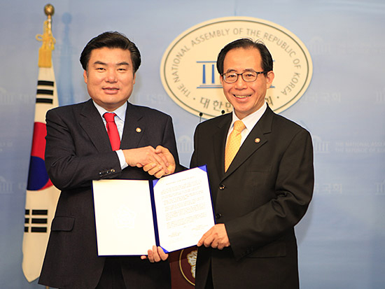 원유철(왼쪽), 김성곤 의원이 재외동포정책 공동추진 합의문 발표 후 악수를 나누고 있다.
