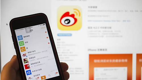 한 스마트폰에 중국의 대표적인 사회관계망서비스(SNS)인 시나(新浪) 웨이보 어플리케이션이 구동돼 있다. 뒤쪽 화면에는 시나 웨이보의 로고가 보인다.